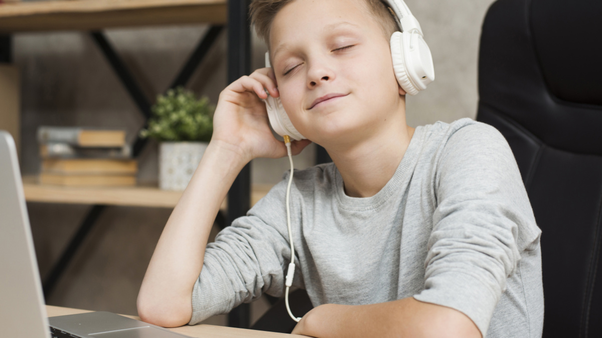 junge mit kopfhörer vor laptop