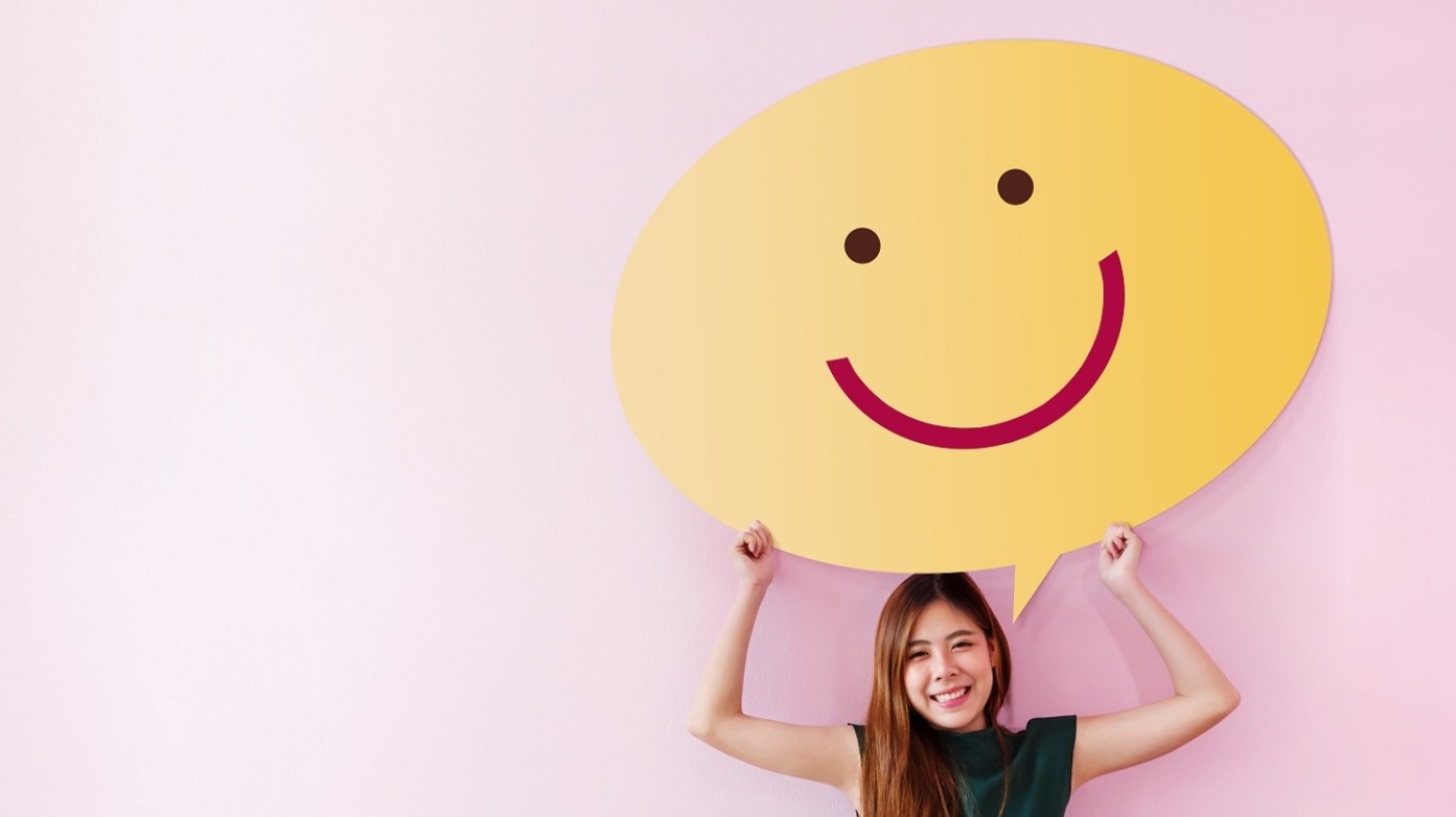 Jugendliche mit Smiley-Schild in der Hand