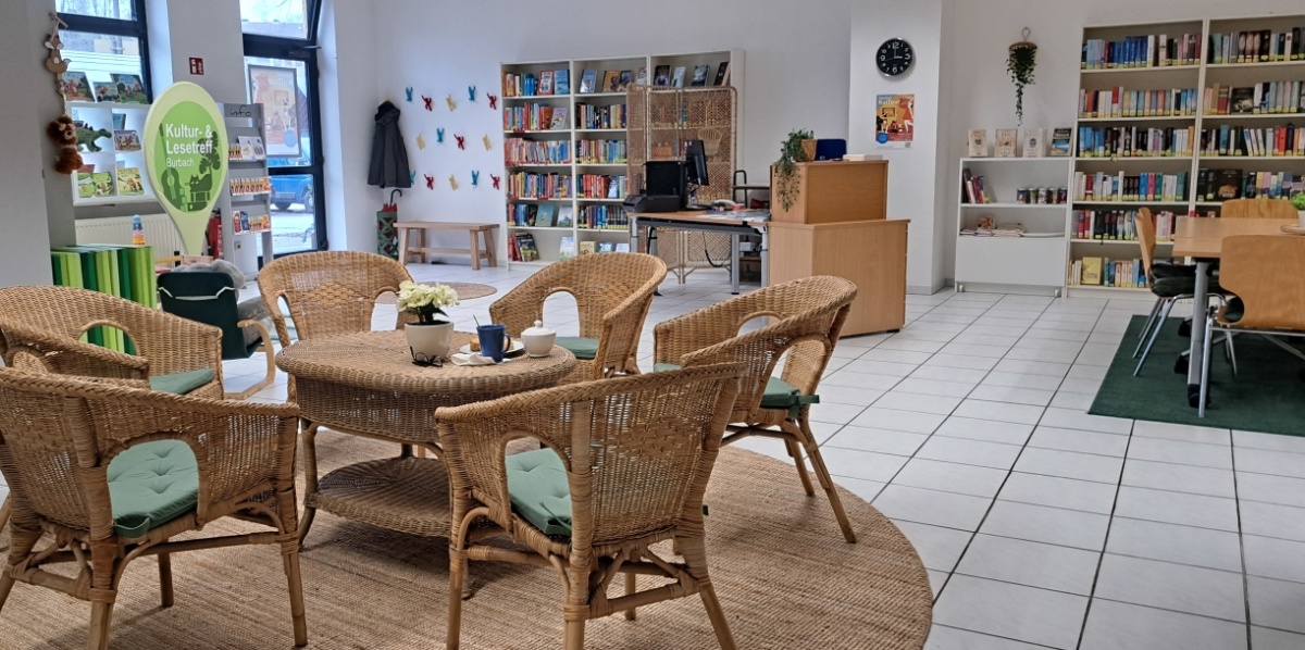 Blick in den Kultur- und Lesetreff Burbach mit Sitzgruppe und Ausleihtheke