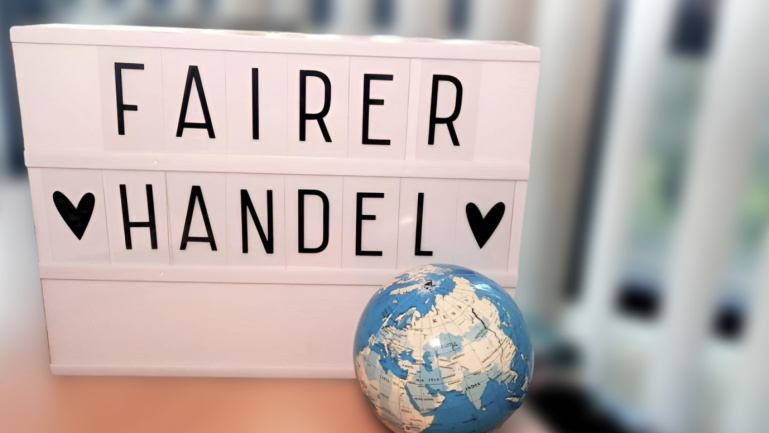 Leuchttafel mit Aufschrift und kleiner Weltkugel davor
